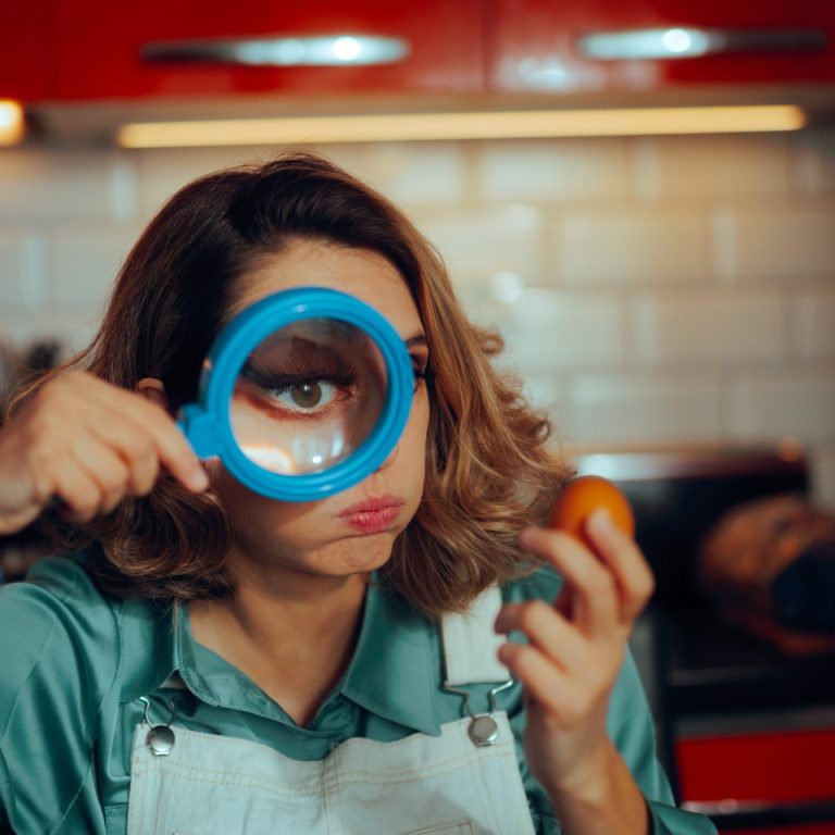 woman with magnifying glass and egg